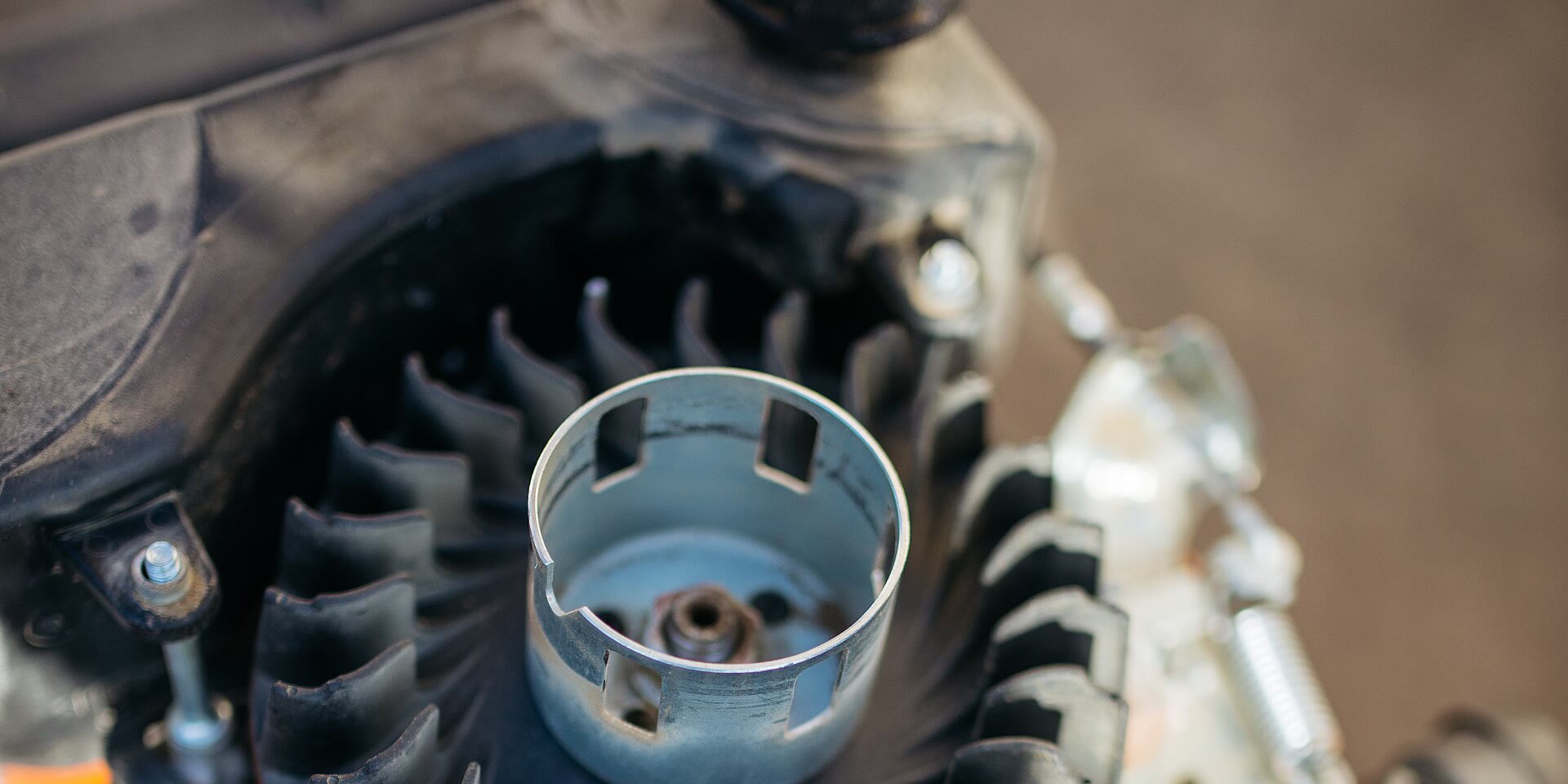 A small engine with its cover off, showing the flywheel fan and cooling fins